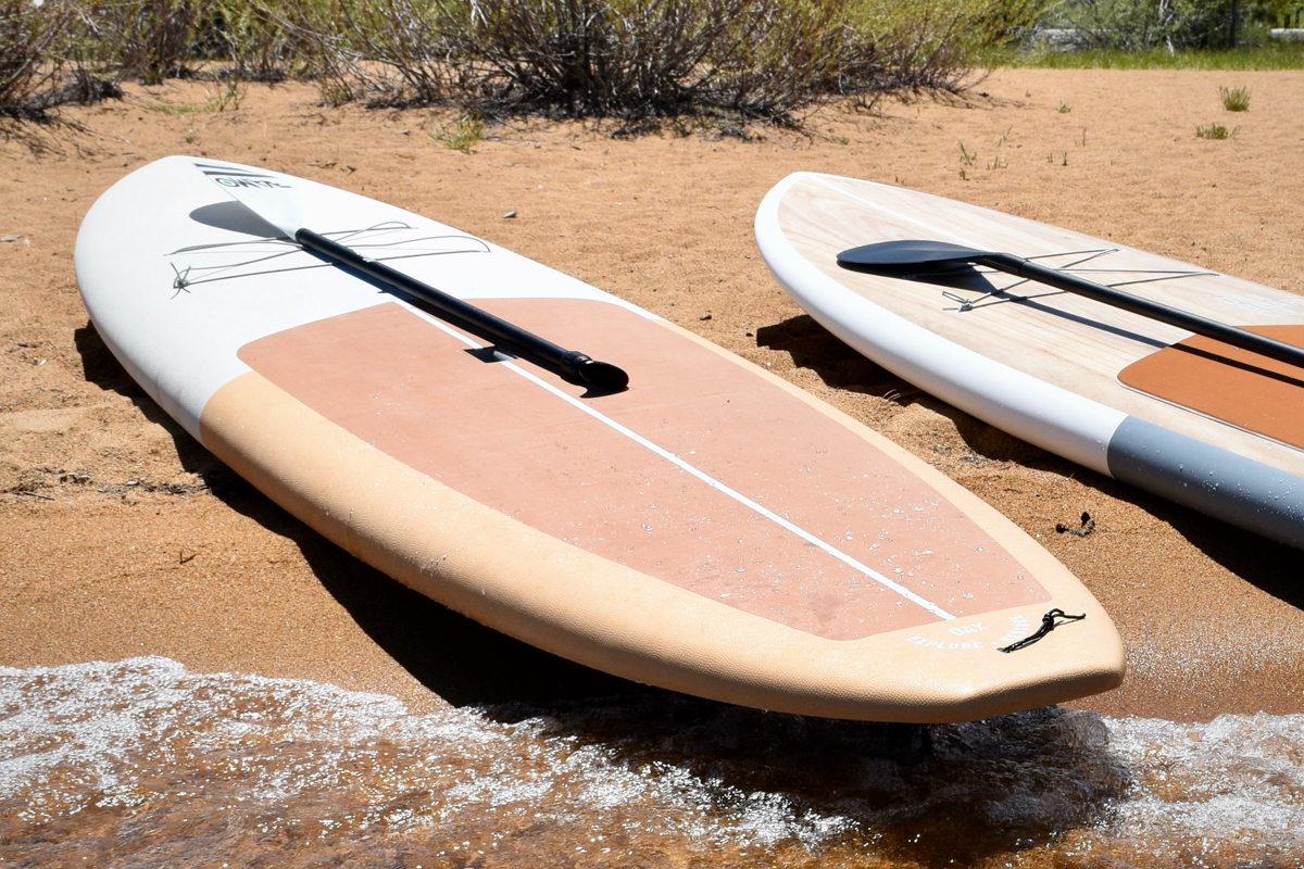 Comparing the Dax DownDog and Drifter SUPs side by side on a beach