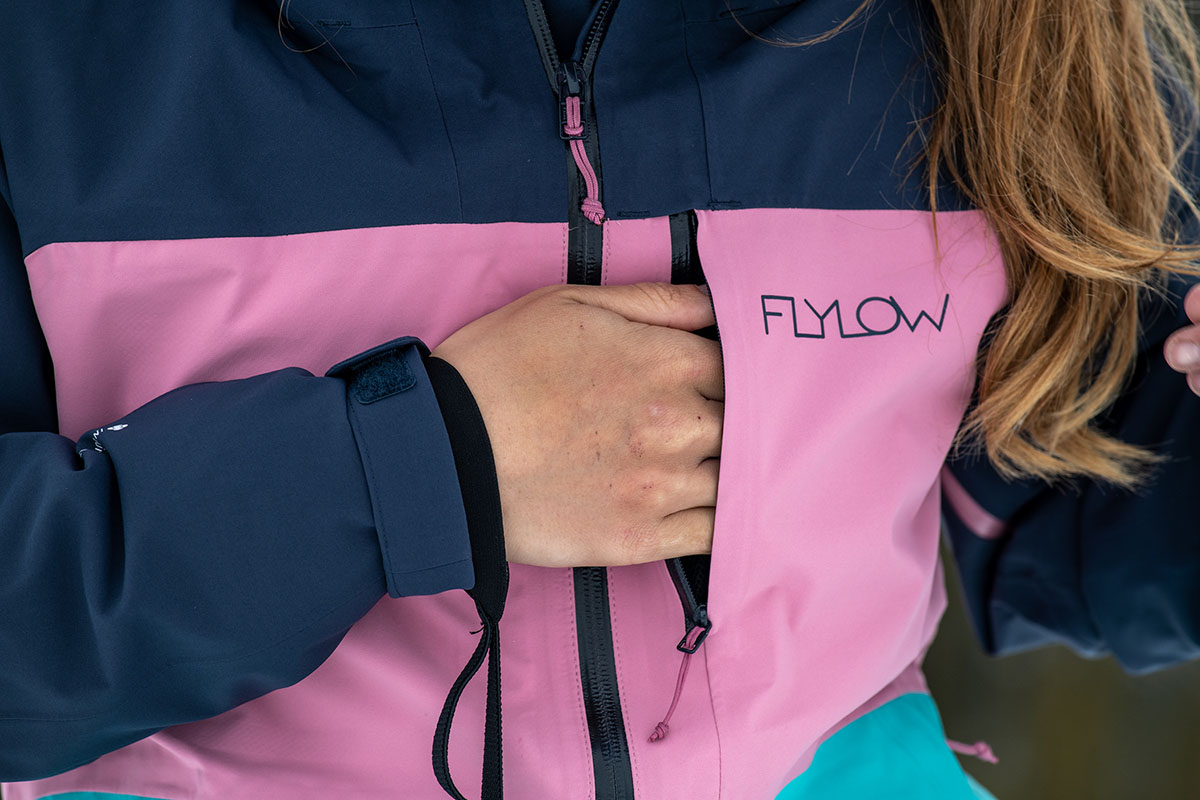 A closeup of the chest pocket on the Flylow Lucy jacket with a hand reaching inside