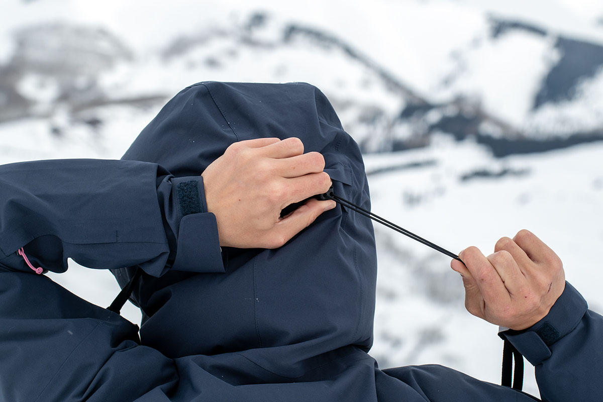 A closeup of the hood of the Lucy jacket from behind getting cinched tight