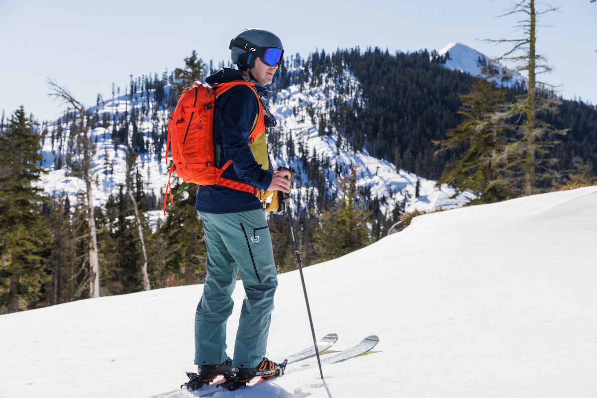 A man wearing a Gregory ski backpack on the side of a ski run at Palisades, Tahoe