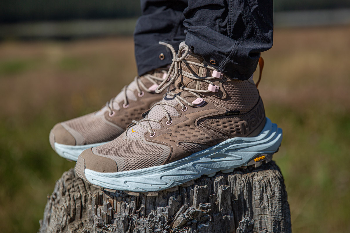 A close up of a pair of hiking boots on a stump