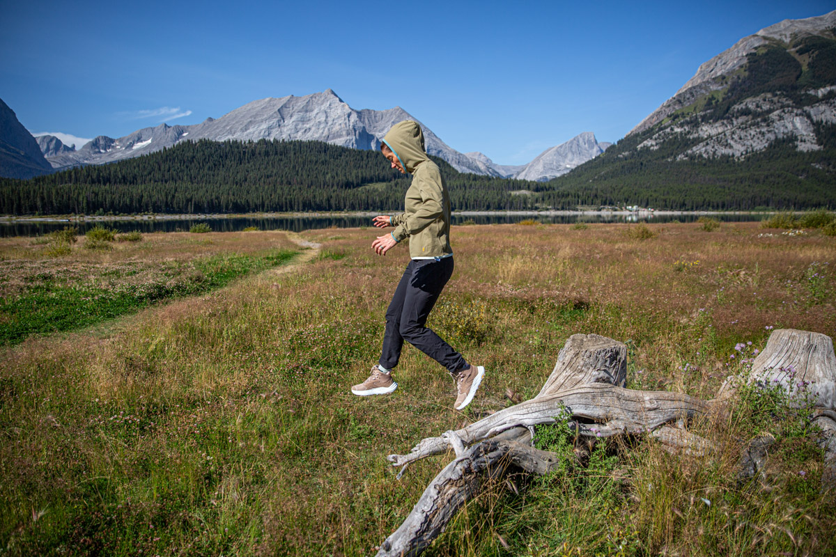 A woman jumping off a log in hiking boots
