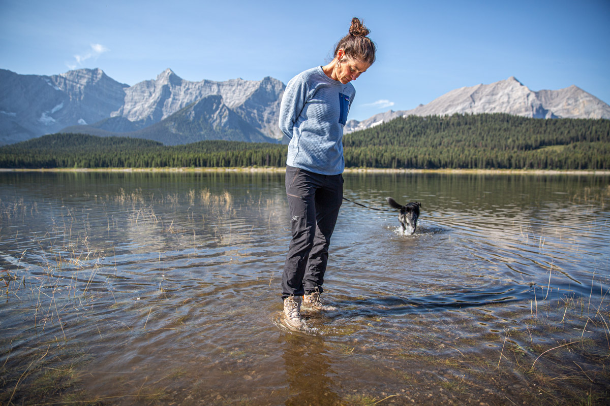 A woman standing in a shallow lake in a pair of hiking boots