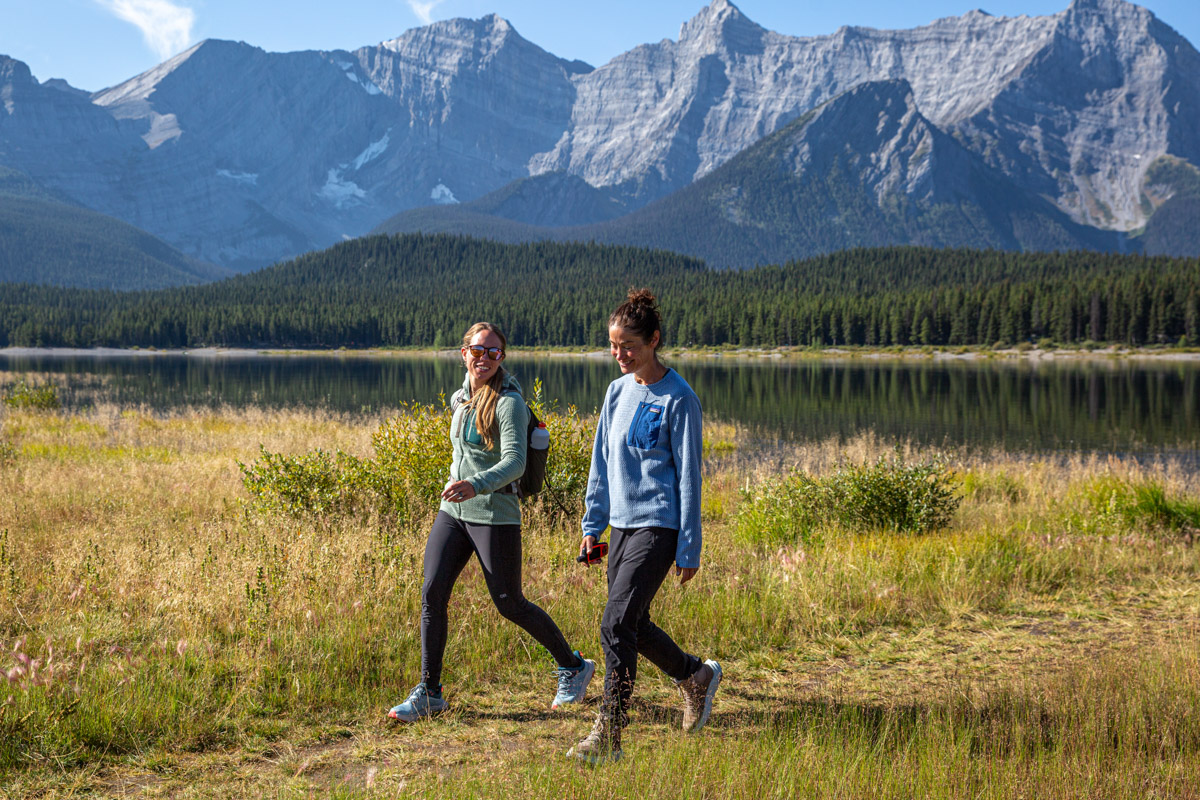 Two women hiking near a lake in hiking boots