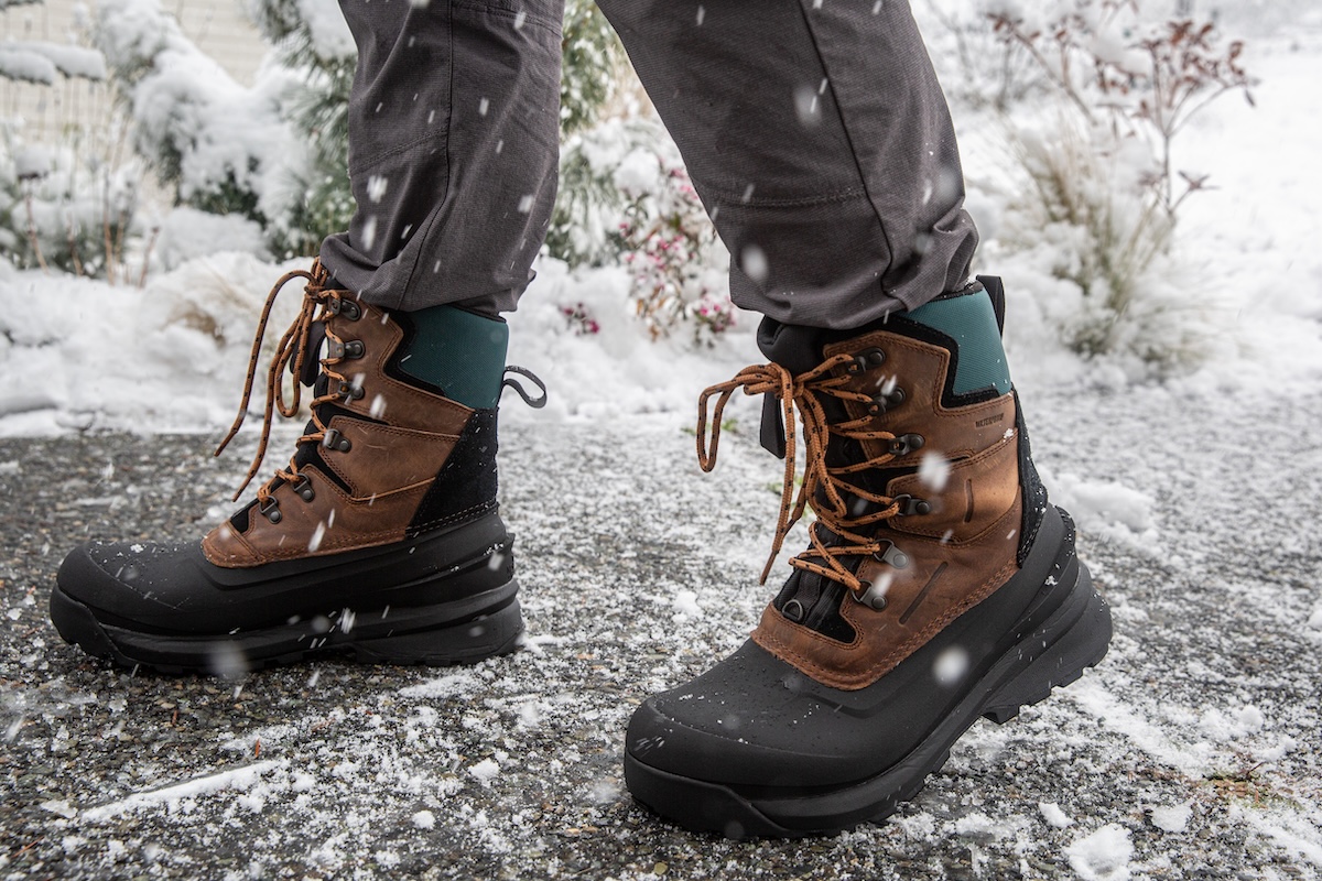 A close up of the North Face Chilkat V 400 boot walking on snowy pavement