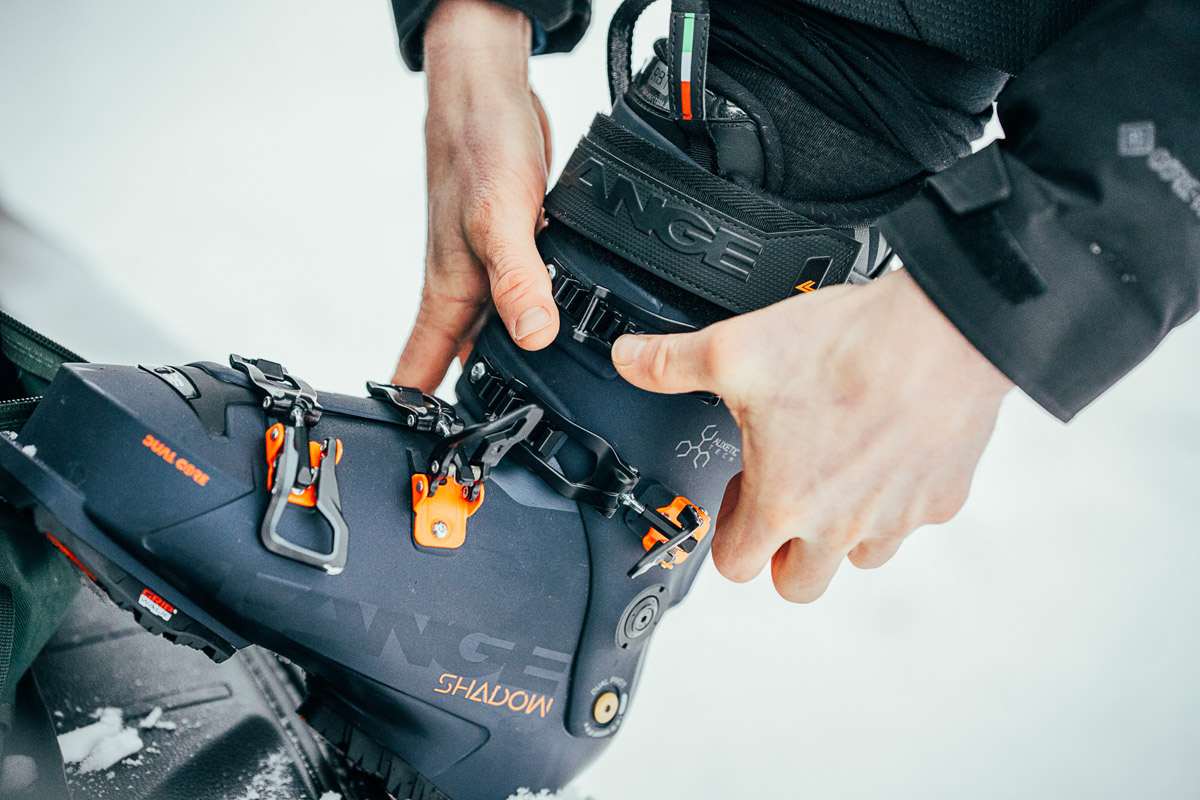 Adjusting the buckles on a blue ski boot