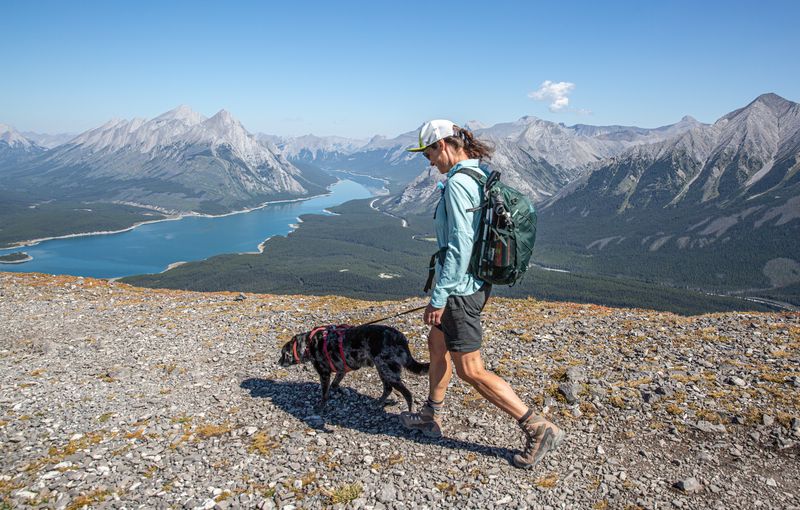 a woman walks in on a ridge line in front of mountains