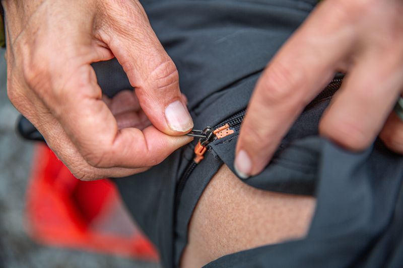 hands unzip a convertible pant leg