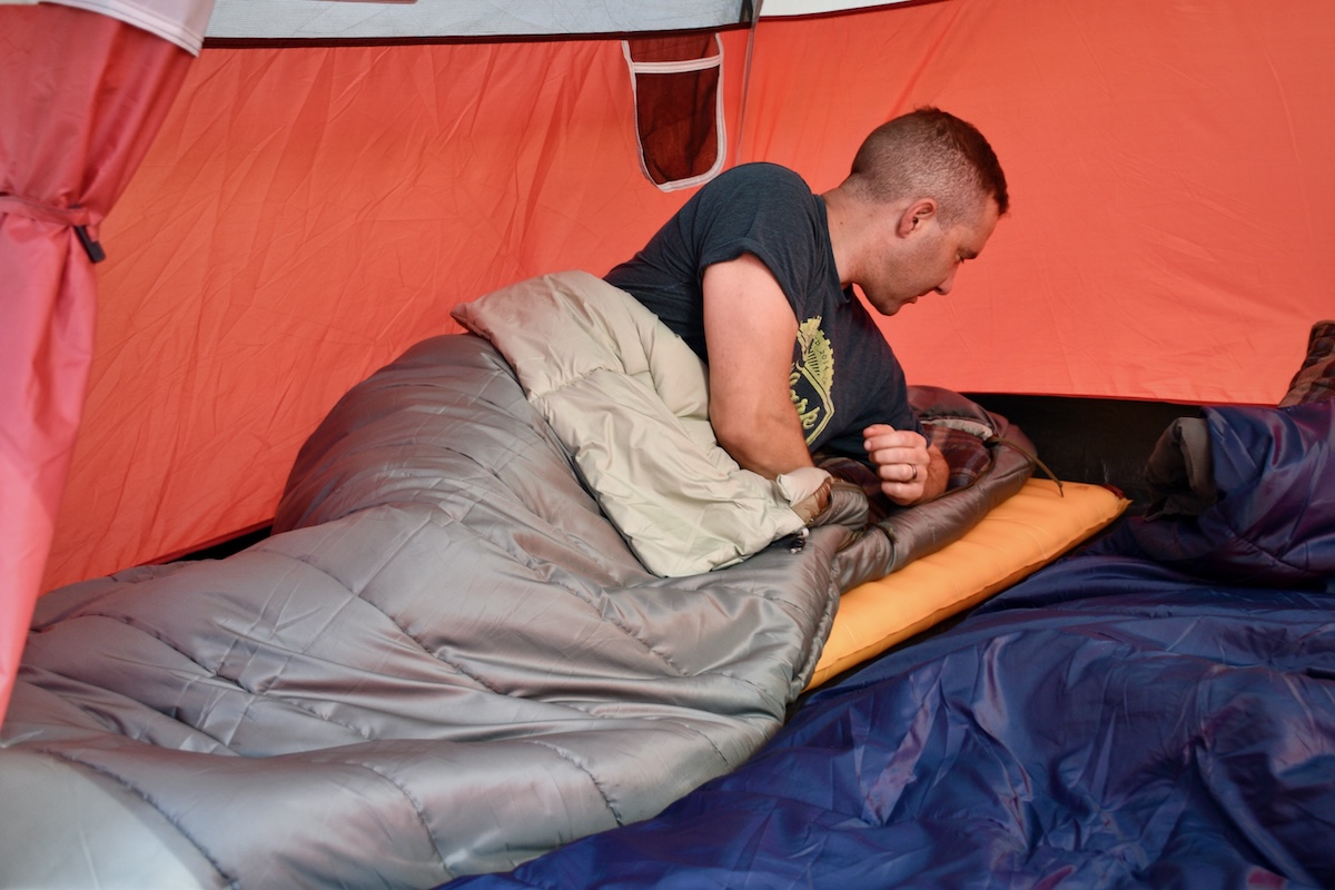 A man rolls over onto his side in the roomy REI Co-op Siesta Hooded 20 Sleeping Bag 