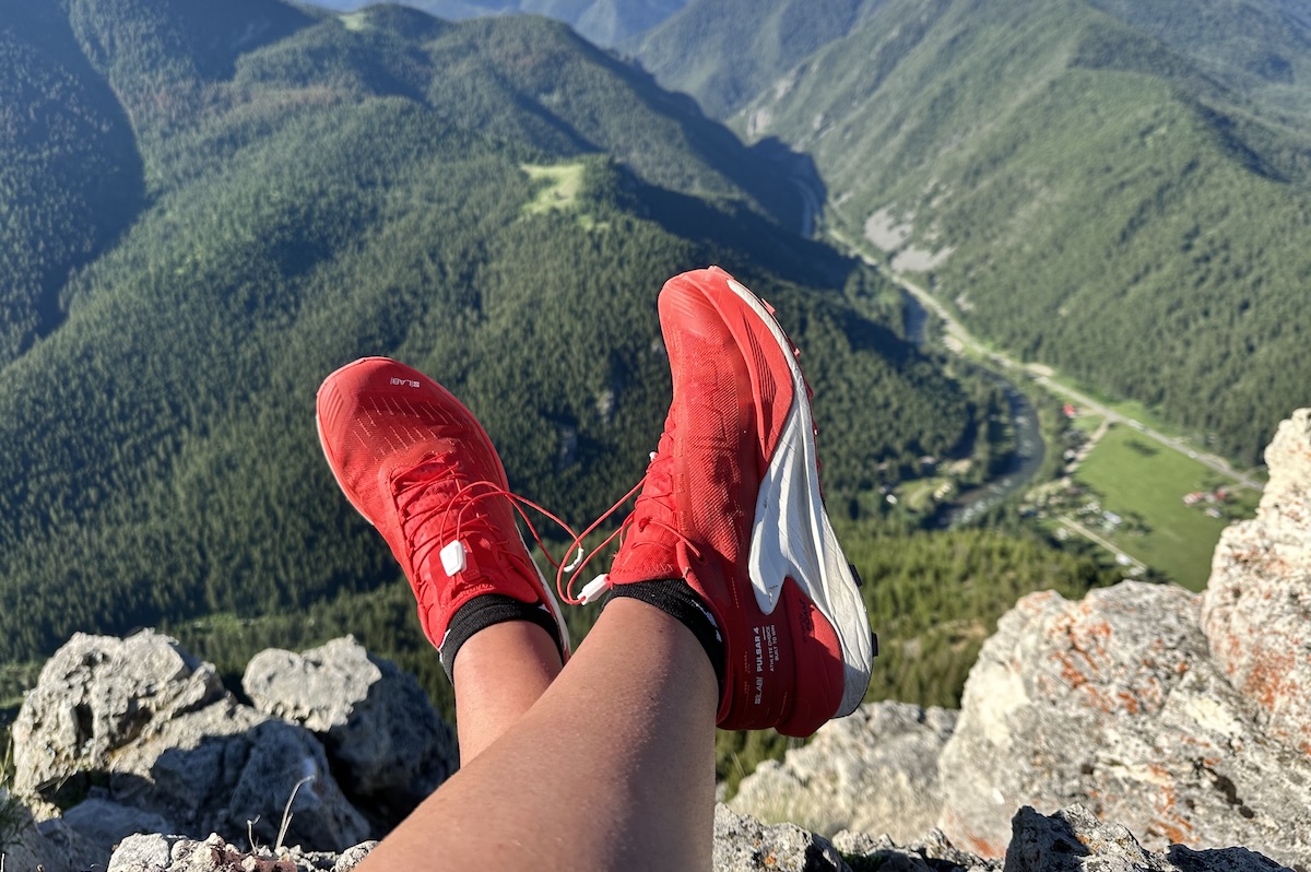 a pair of red shoes dangling over a ledge _0