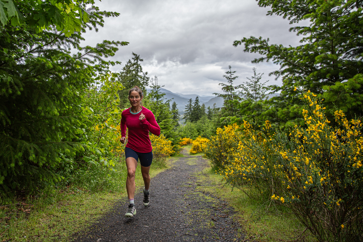 A woman running on hard gravel trail in trail running shoes