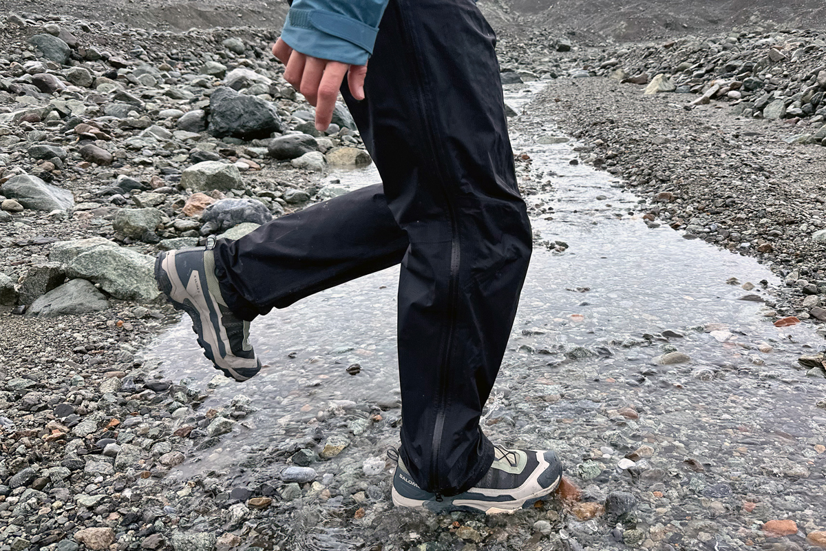 Taking a big step in a shallow rocky stream in hiking shoes
