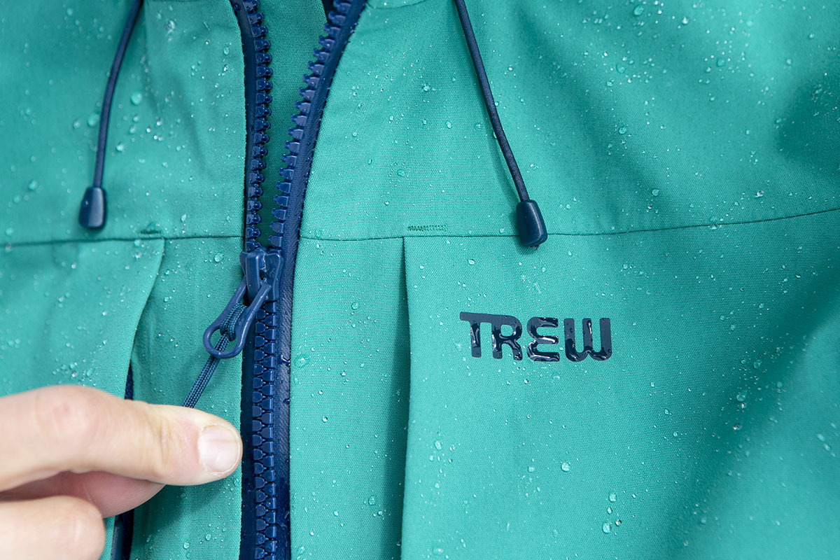 A closeup of the Stella Primo jacket showing the Trew logo and water beading on the surface
