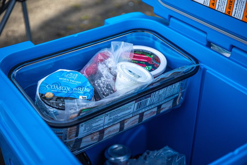 Looking into a blue cooler with a basket of dry goods