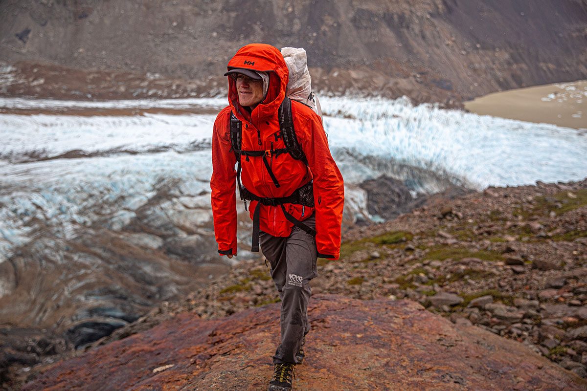 A hiker bundles up in their Helly Hansen jacket while exploring the outskirts of a glacier.