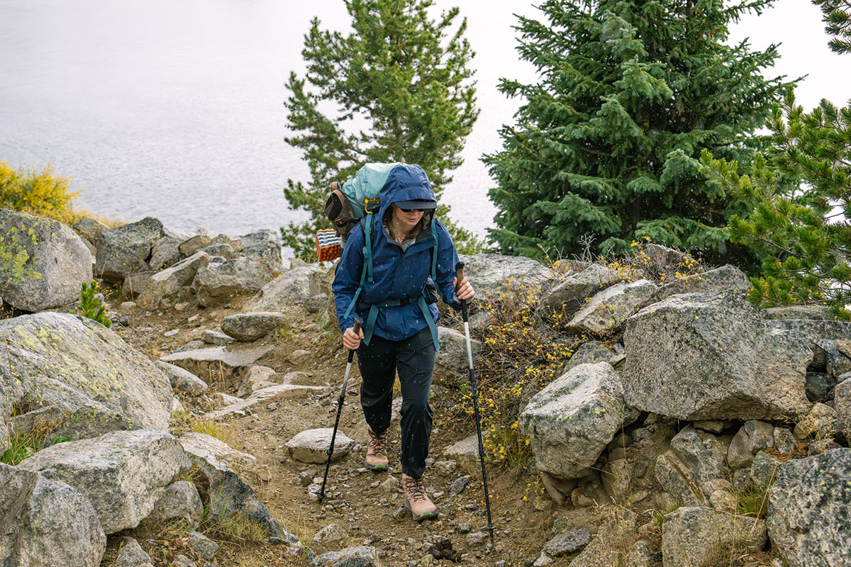 A woman hiking on a rock trail with hiking poles