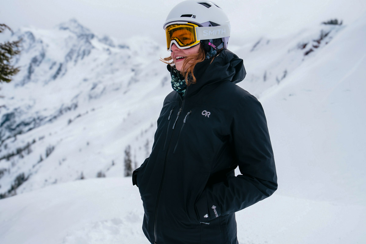 A woman standing in the snow with budget ski gear