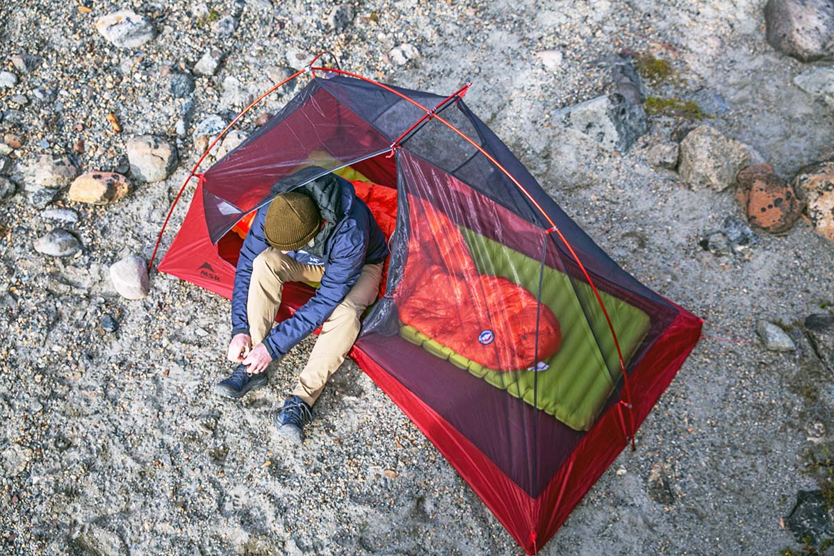 A camper in a lightweight tent uses a minimal, but warm, sleeping pad.
