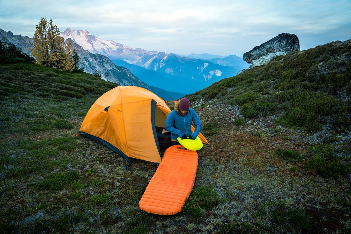 A camper sets up their camp high in the mountain wilderness.