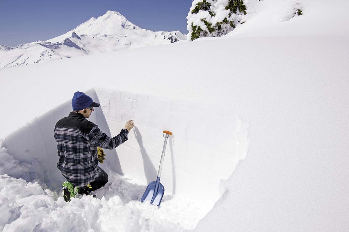 A man checking snow stability in snow dug-out
