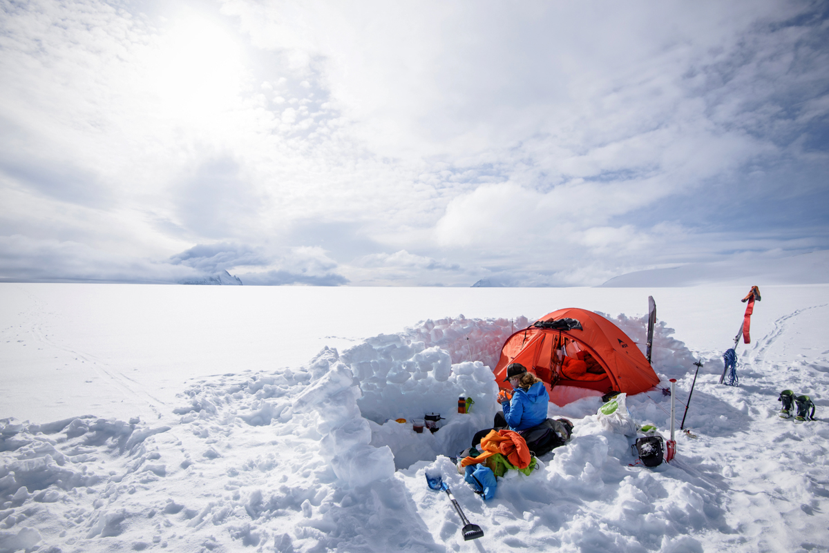 A woman sitting at a snow camp