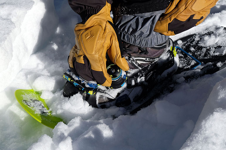 Adjusting a Boa dial on a snowshoe
