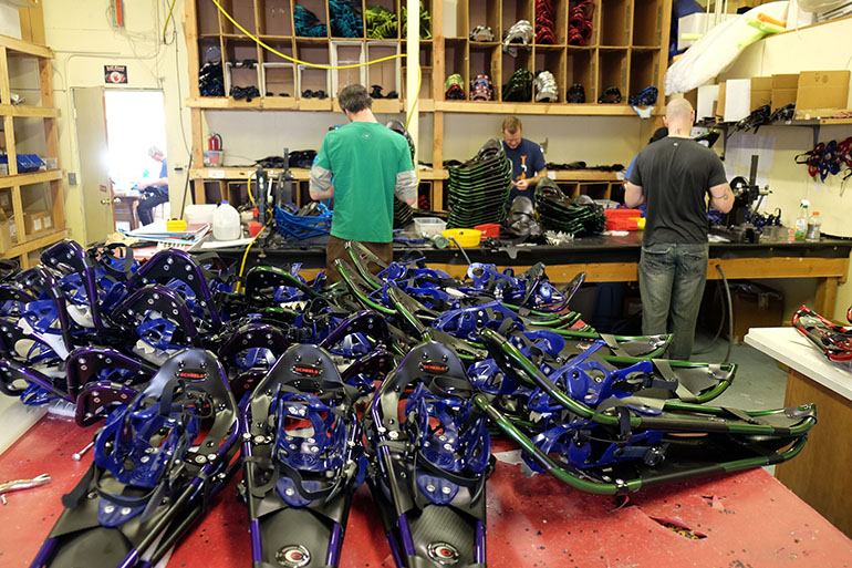 A pile of snowshoes on a table in a snowshoe shop