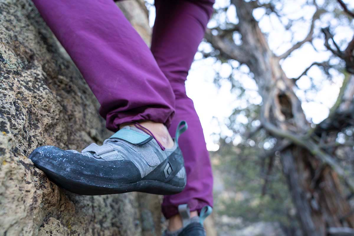 A close up of a foot in a climbing shoe on a vertical rock face