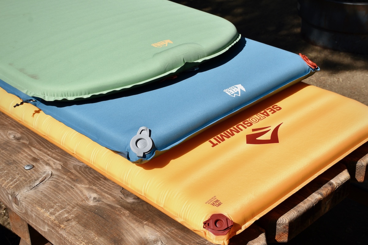 A stack of camping mattresses laid out in the sun
