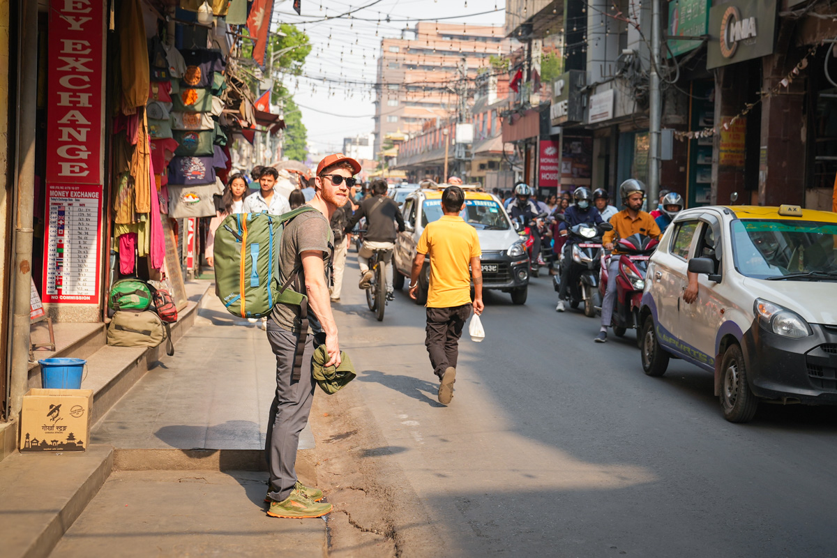 A man on the street in Nepal wearing the Bluffworks Envoy Lightweight Travel Pants