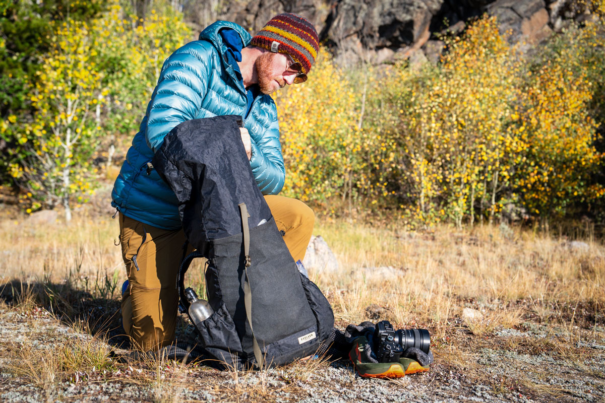 A backpacker takes time to pack his backpack before a long trip. 