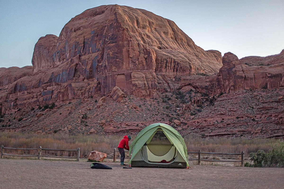A tall, green tent is pitched in the red rock canyons of Utah.