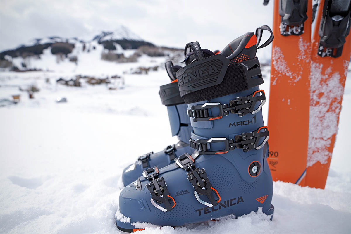 A pair of ski boots are placed next to a pair of skis. 