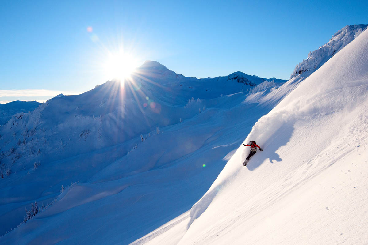 A splitboarder making a turn in powder in the backcountry