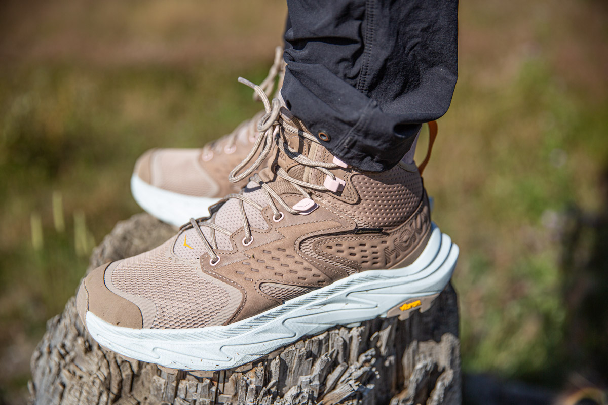 A pair of brown hiking boots standing on a stump