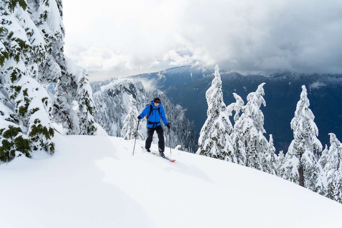 A man skins up a snowy slope in the backcountry