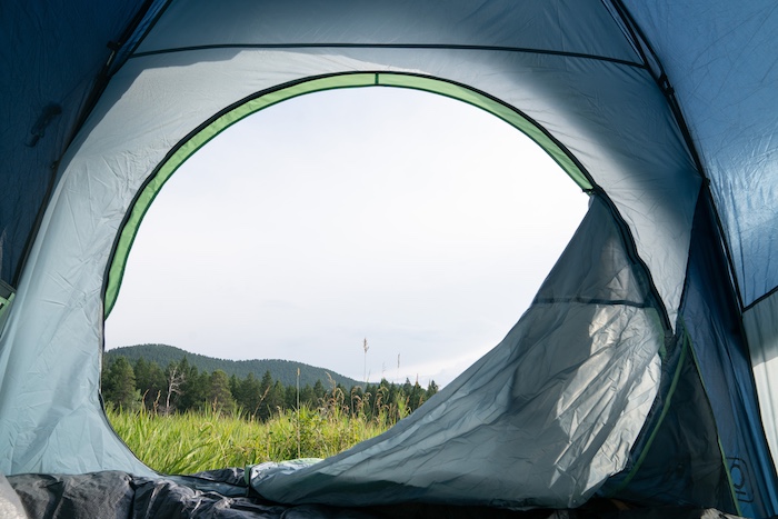 A beautiful, distant view through the door of a spacious camping tent.