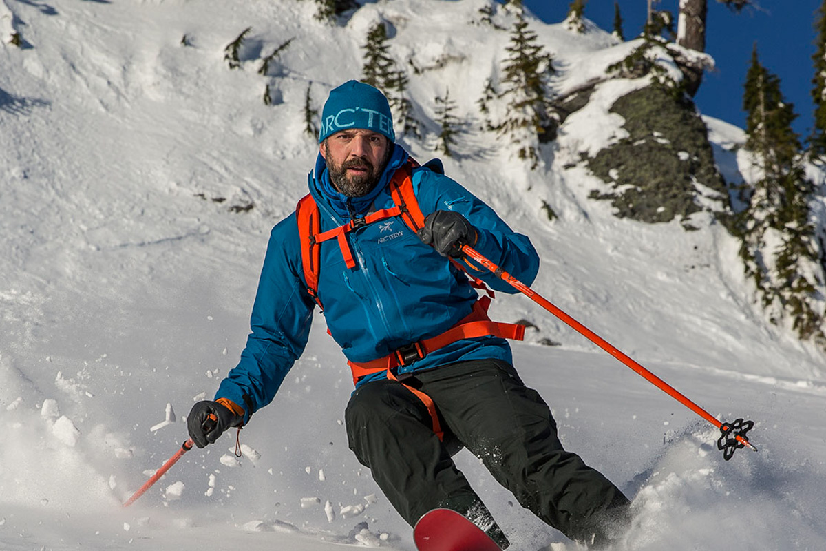 A man skis down a steep snowy slope in the backcountry
