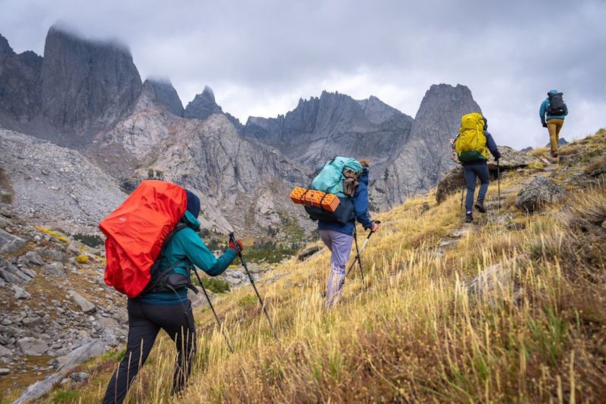 A group of hikers traverse a rocky ridge in the Wind River Mountains.
