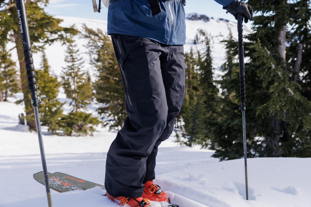 A closeup of a pair of ski pants out on a snowy hill amidst the trees