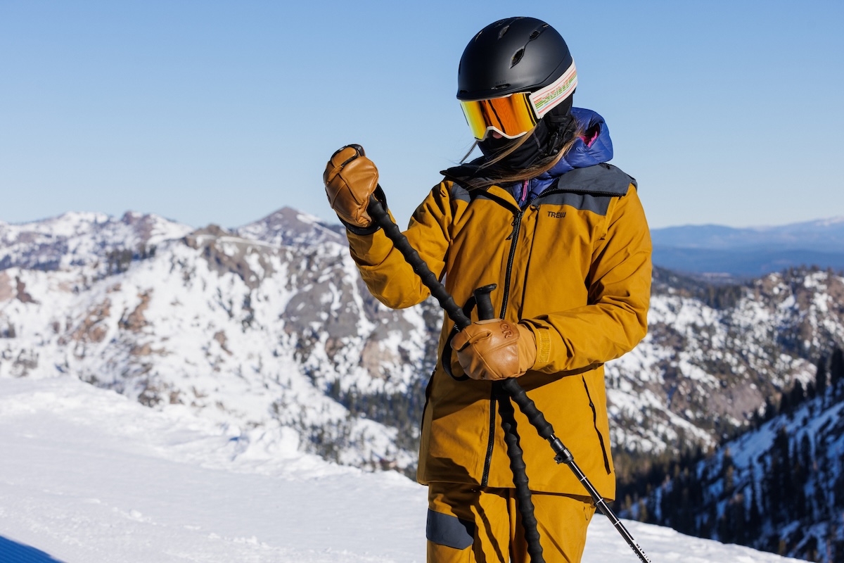 A suited up skier assesses one of their ski poles