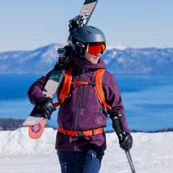 Nick carrying skis on a sunny day at Palisades resort in Lake Tahoe, CA