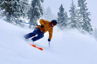 A skier comes down a powdery slope at high speed
